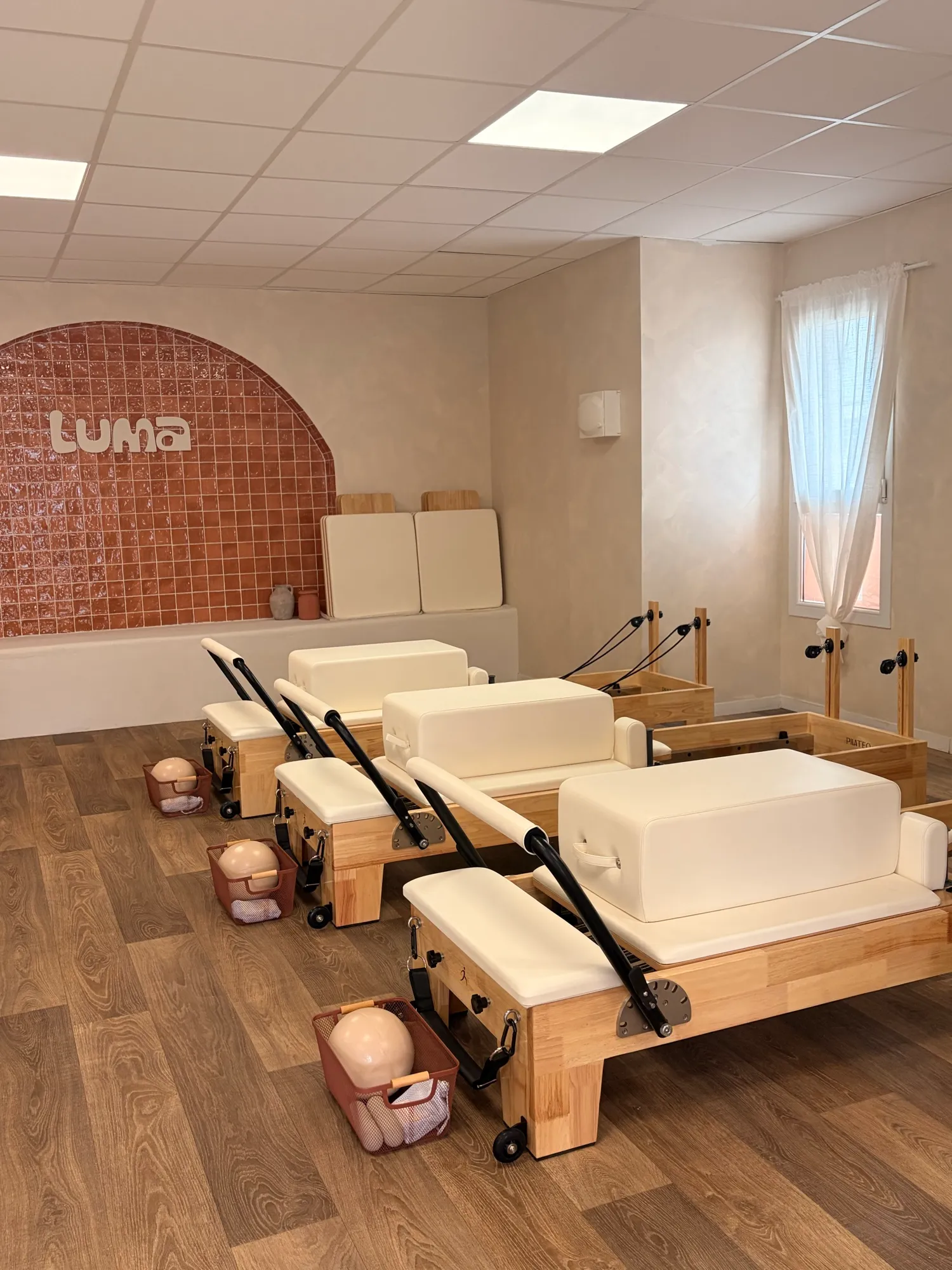 La salle Reformer du studio Luma Pilates Club à Six-Fours-les-Plages, machines en bois et arche en zellige terracotta